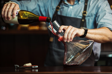 Wine being carefully poured into a decanter during service
