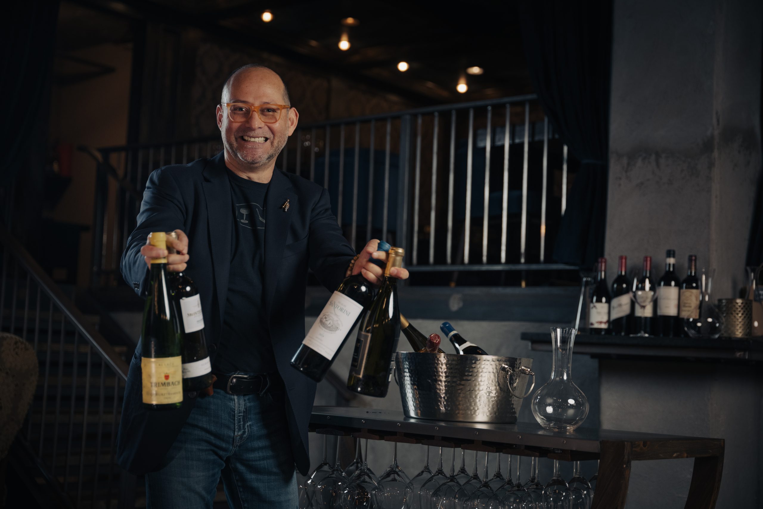 Pablo Aguilar presenting bottles beside the WiNEisFOOD wine cart